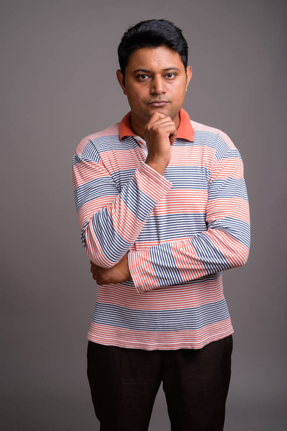 Szürke háttérrel indiai fiatalember portréja - Fotó, kép