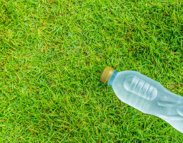 bottle of clear still water in a grass field - Photo, Image