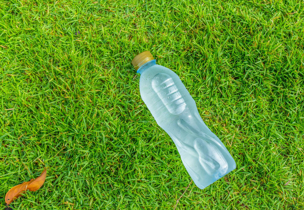 Бутылка чистой воды на травяном поле
 - Фото, изображение