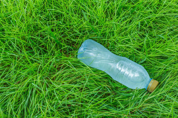 Botella de agua clara en un campo de hierba
 - Foto, Imagen