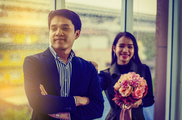 Woman holding roses bouquet apologized to a man in love, in office With  relaxed mood. - Foto, Imagem