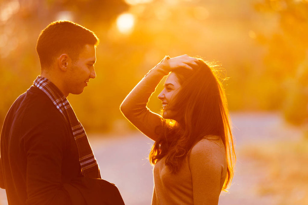 junges Paar tauscht Emotionen vor Sonnenuntergang aus. - Foto, Bild