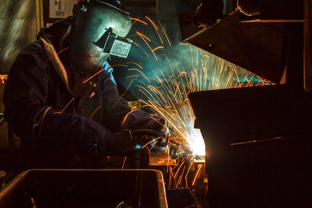 Welder working a welding metal with protective mask and sparks - Foto, imagen