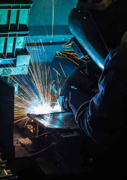 soldador está soldando la estructura de acero con todo el equipo de seguridad en fábrica
 - Foto, Imagen