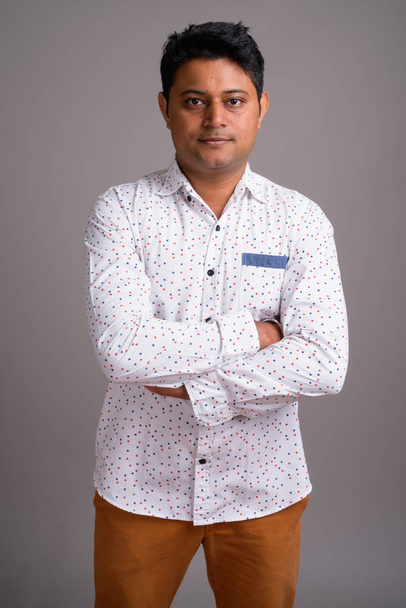 Portrait of young Indian businessman against gray background - Fotografie, Obrázek