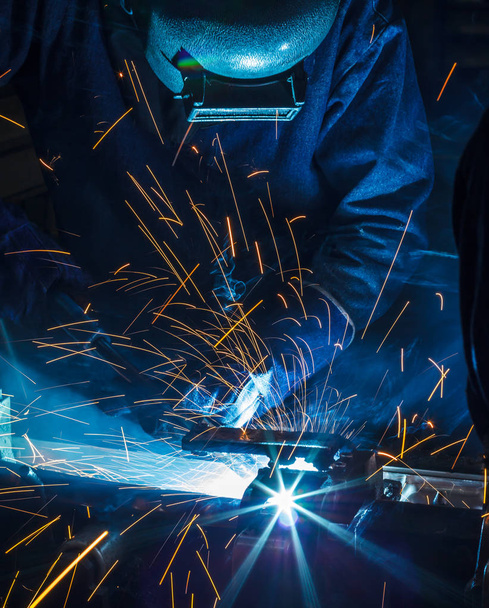 soldador está soldando la estructura de acero con todo el equipo de seguridad en fábrica
 - Foto, Imagen