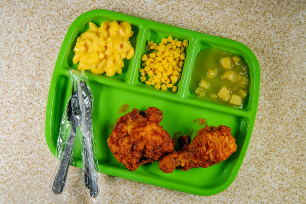 Klasse Schule Mittagessen Tablett mit frittierten Hühnerkeulen mit Makkaroni und Käse Mais und Apfelmus - Foto, Bild