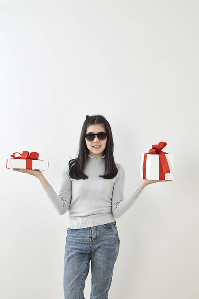 Jeune asiatique femme montrer OK avec une boîte-cadeau sur fond mural gris vif
 - Photo, image