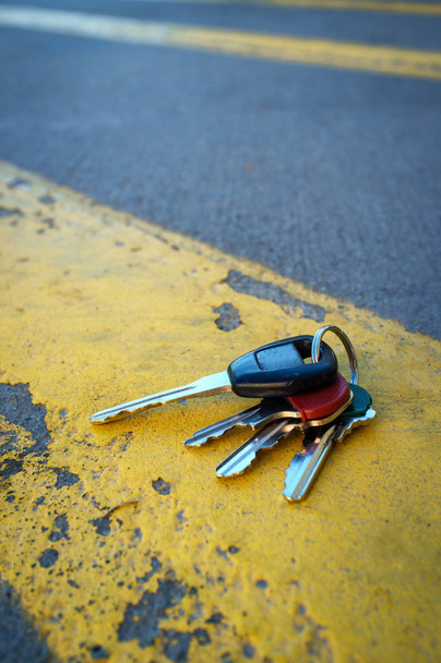 Потерянные ключи от машины на проблемной дороге окрашены в желтые линии - Фото, изображение