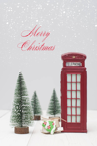 Toy London red phone booth, gifts and christmas trees on light winter background - Fotó, kép