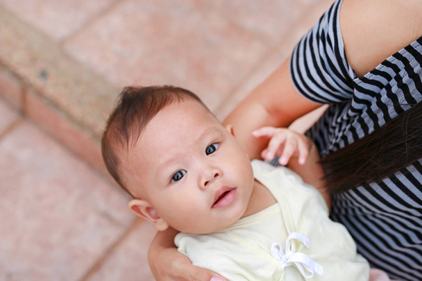 Yakın çekim Asya bebek çocuk annesi kucaklama görünümlü kamera ile yalan. - Fotoğraf, Görsel
