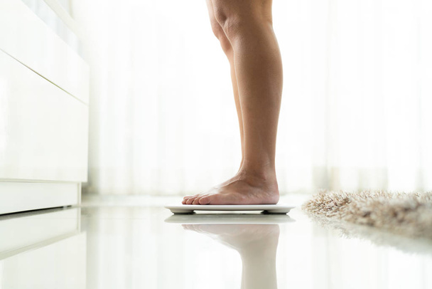 young woman standing on digital weight scale - Photo, Image
