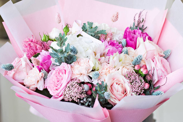 Gyönyörű csokor, rózsa és és ranunculus virág rózsaszín csomagolópapír. Rózsa és egyéb kényes gyönyörű virág. - Fotó, kép