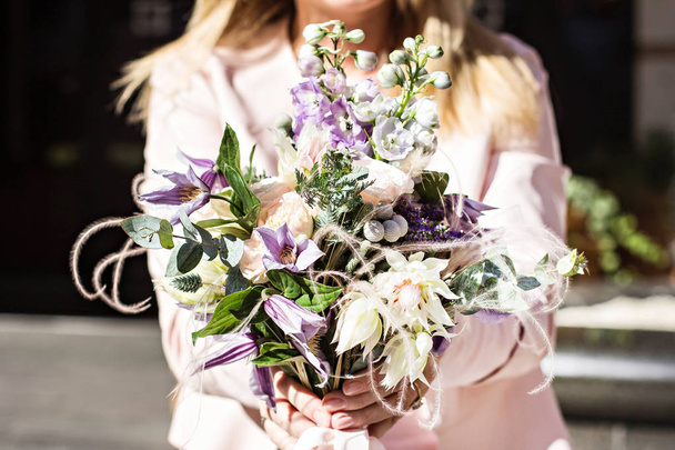 Beautiful bouquet with delicate flowers. Pink-white-purple bouquet. Bridal bouquet in female hands - Foto, afbeelding
