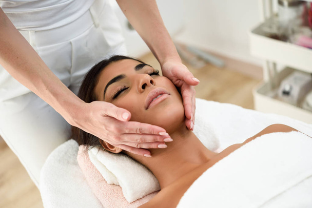 Mujer árabe recibiendo masaje en la cabeza en el spa centro de bienestar. Conceptos de belleza y estética
. - Foto, imagen