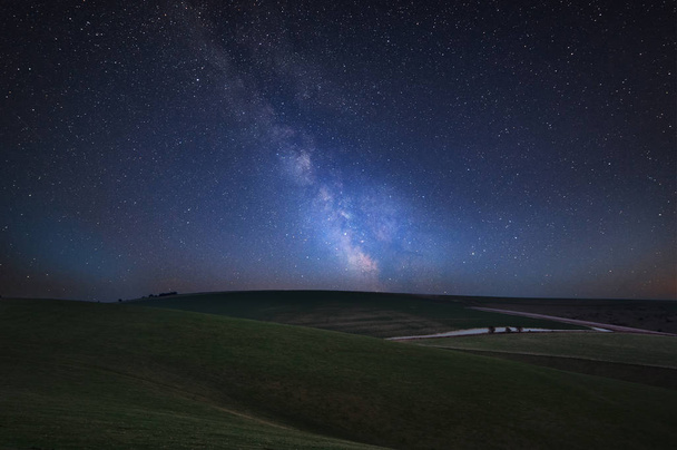 Superbe image composite vibrante de la Voie lactée sur un paysage de campagne anglaise vallonnée
  - Photo, image