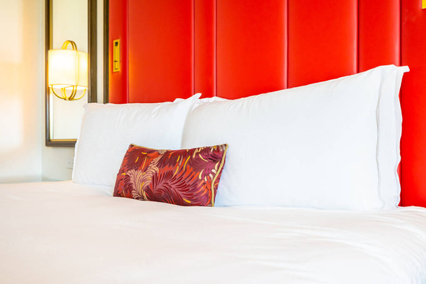 Комфортная подушка на кровати с легким ламповым декором интерьера спальни
 - Фото, изображение