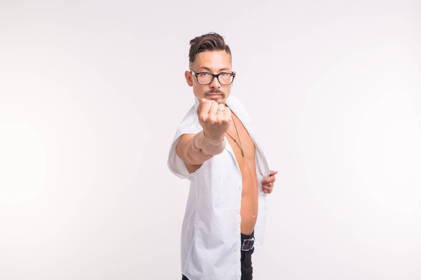 Pessoas, emoções e conceito de gesto - homem bonito em camisa branca mostrando seu punho no fundo branco com espaço de cópia
 - Foto, Imagem