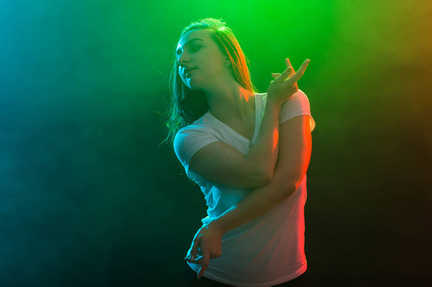 Dance, sport and people concept - Cheerleading girl dancing on multicolored background. - Фото, изображение