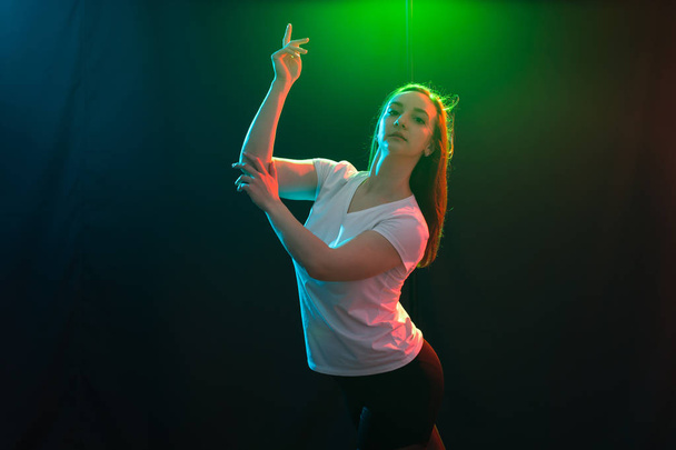 People and dancing concept - Young fitness woman dancing jazz funk over colored background - Photo, Image