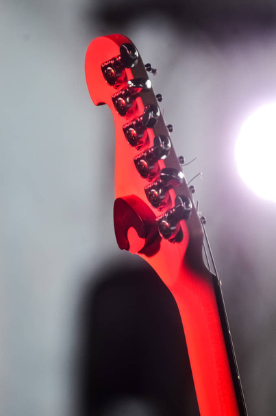 chitarra elettrica si erge sul palco sotto i raggi dei riflettori rossi prima del concerto su sfondo scuro. concetto di musica e festival rock
 - Foto, immagini