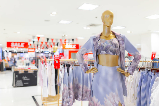 Imagem borrada de vitrine boutique interior da loja de pano com manequins em vestidos da moda para o fundo
. - Foto, Imagem