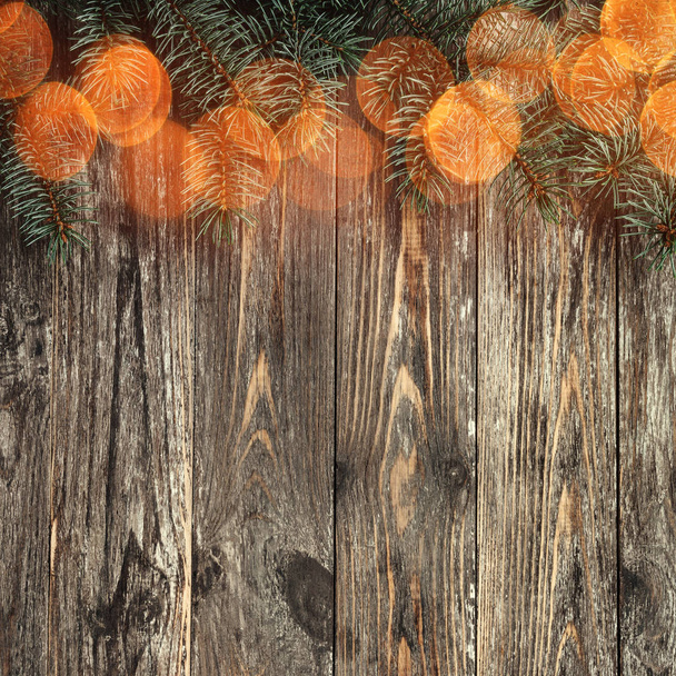 Old wood background with fir branches. Space for a greeting message. Christmas card. Top view. Congratulation card with light effect. - Фото, изображение