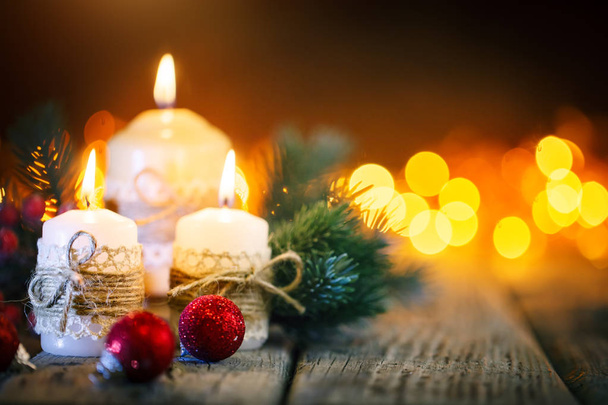 Merry Christmas and happy New year. Candle and Christmas toys on a wooden table on the background of a garland. Bokeh. Selective focus. Background with copy space. - Foto, immagini
