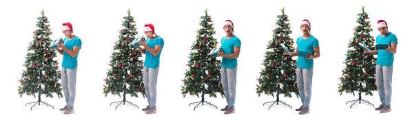 Mladý muž zdobení vánoční strom izolované na bílém - Fotografie, Obrázek