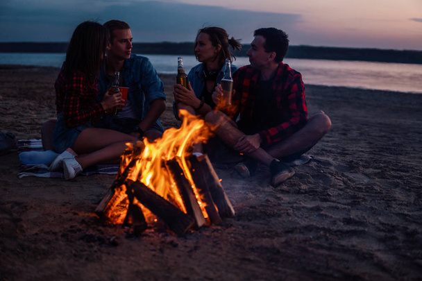 Młodzi przyjaciele urządzić sobie piknik z ogniskiem na plaży - Zdjęcie, obraz