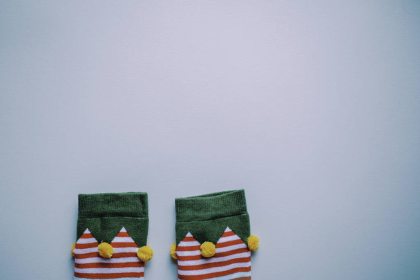 flat lay top view of elf socks on blue background. perfect for a festive merry xmas greeting card. christmas background. enough room for copy space and text. - Zdjęcie, obraz