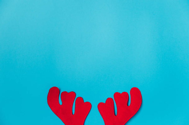 christmas background. flat lay top view of reindeer antlers on blue background. perfect for a merry xmas greeting card. enough room for copy space. - Photo, Image
