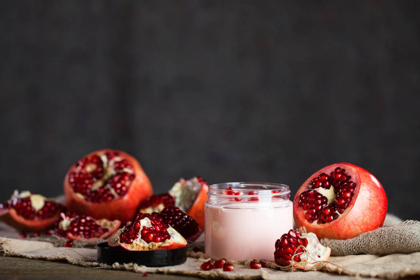 Pomegranate body cream on a wooden surface. Closeup - Fotó, kép