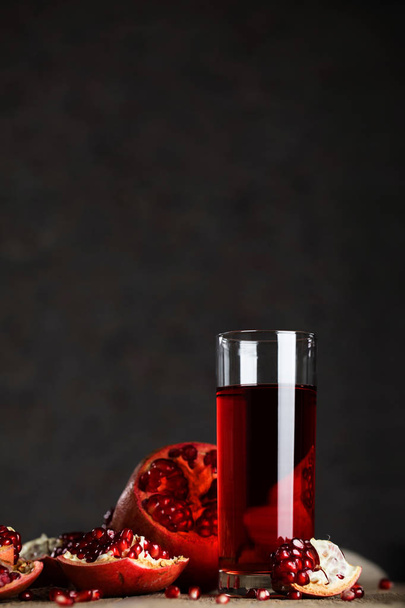 木製の表面のザクロ ジュースのガラス。クローズ アップ  - 写真・画像