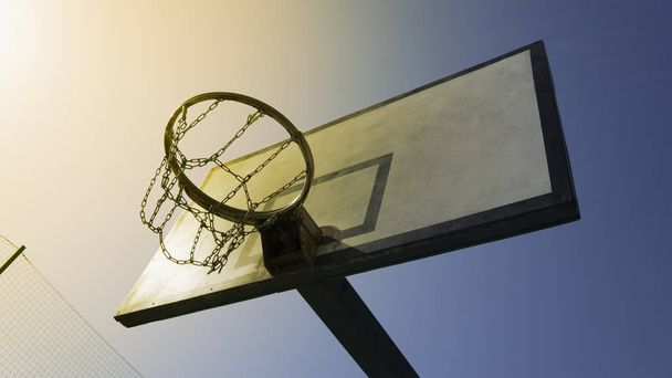 Een ring van de basketbal verlicht door de felle zon - Foto, afbeelding
