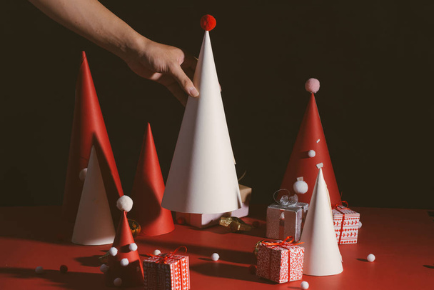 Creative red and white Christmas trees made of paper on dark background - Photo, Image