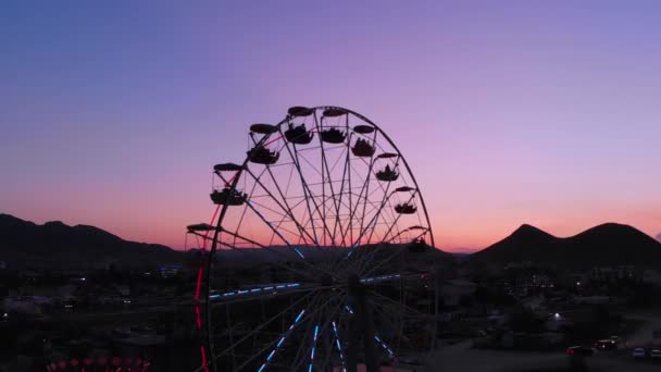 Riesenrad auf dem Hintergrund des Meeres bei Sonnenuntergang. Blick von oben - Filmmaterial, Video