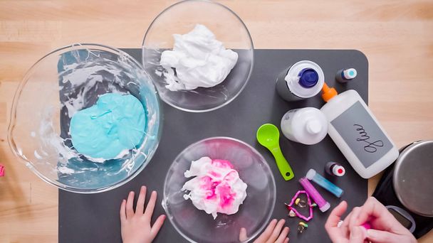 Step by step. Flat lay. Mother and daughter making colorful fluffy slime. - Foto, imagen