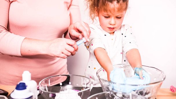 Step by step. Mother and daughter making colorful fluffy slime. - Foto, Imagem