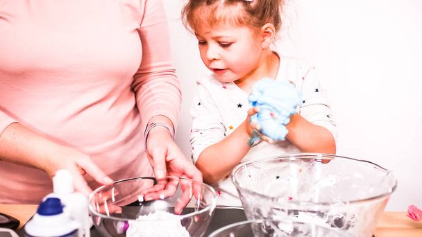 Step by step. Mother and daughter making colorful fluffy slime. - Foto, Imagem