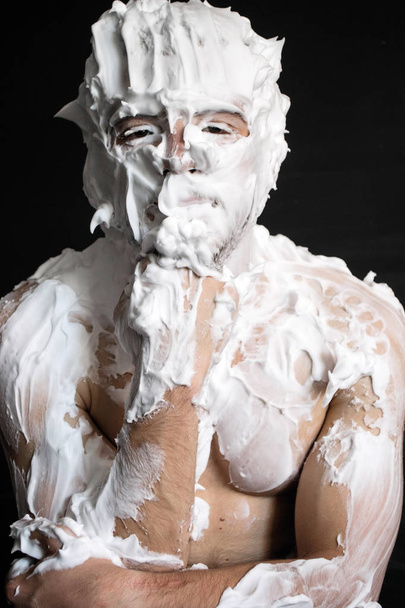 portrait of a strong guy smeared with shaving foam - Photo, Image