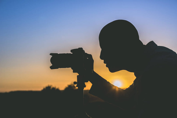 Silueta černých fotograf fotit při západu slunce. Obrázek s kopií prostor. - Fotografie, Obrázek