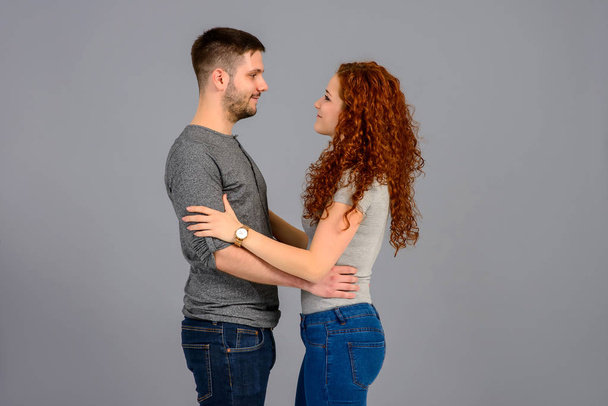 A beautiful young couple standing face to face and holding each others hand - Foto, Bild