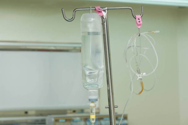 eine Flasche mit Kochsalzlösung, die im Operationssaal auf dem Ständer hängt. - Foto, Bild