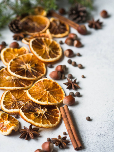 Bright Christmas or New Year background - dry orange slices and spices, spruce and cones. Ingredients for making winter seasonal drink - mulled wine on gray background - Фото, зображення