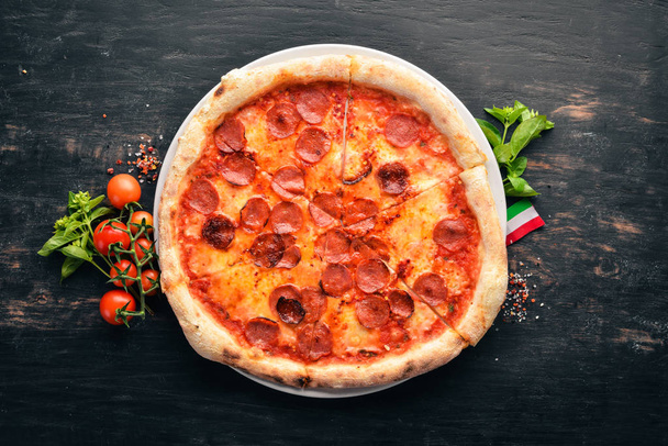 Pizza Margarita with sausages and tomato sauce. On a wooden background. Top view. Free space for your text. - 写真・画像