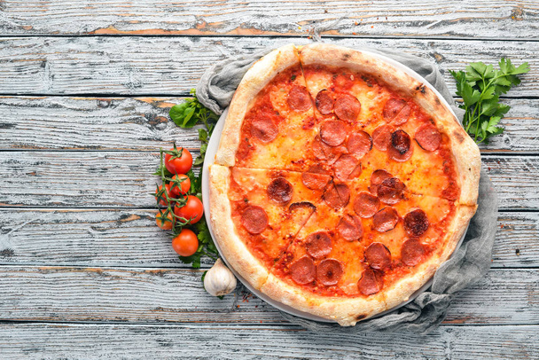 Pizza Margarita with sausages and tomato sauce. On a wooden background. Top view. Free space for your text. - Foto, Imagen