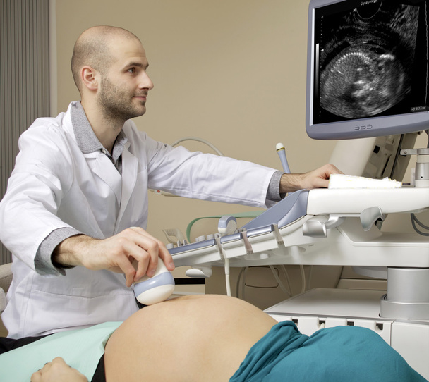 Portrait of young male technician operating ultrasound machine - Fotó, kép