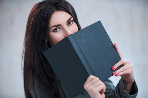 Young business woman with book portrait on gray wall background - Φωτογραφία, εικόνα