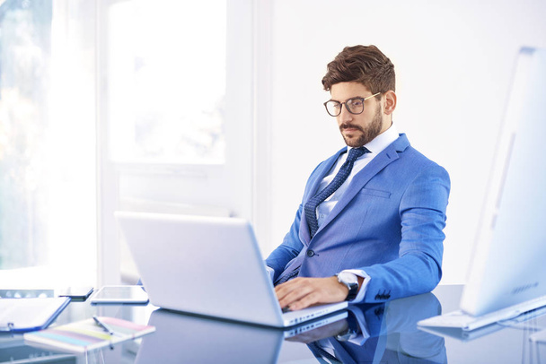 Tiro de pensar joven asesor financiero hombre de negocios utilizando su computadora portátil en la oficina
.  - Foto, imagen